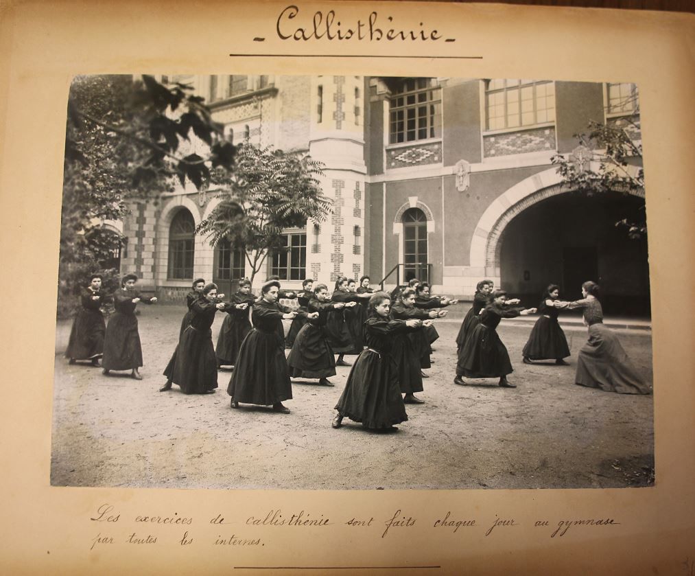 Page d'album intitulée « Callisthénie » : des lycéennes alignées font leurs exercices dans la cour, vers 1902